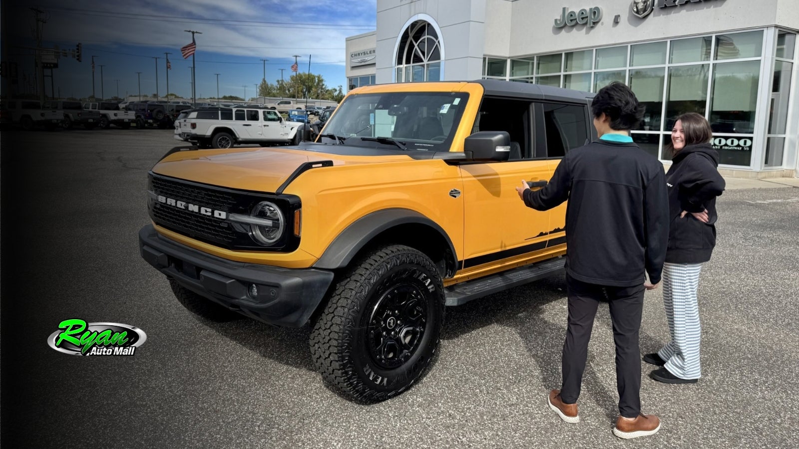Shopper looking at a used vehicle with a salesperson at Ryan CDJR in Buffalo, MN