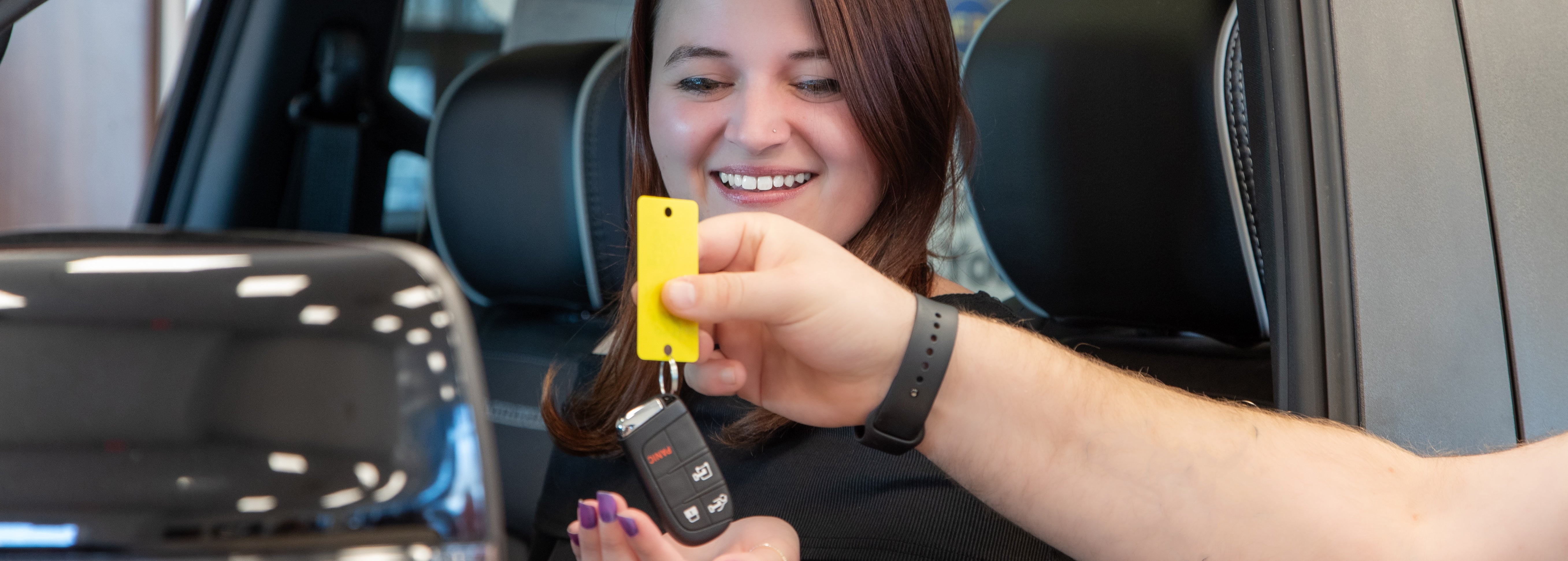 Dealership salesperson agreeing the sale with a customer.